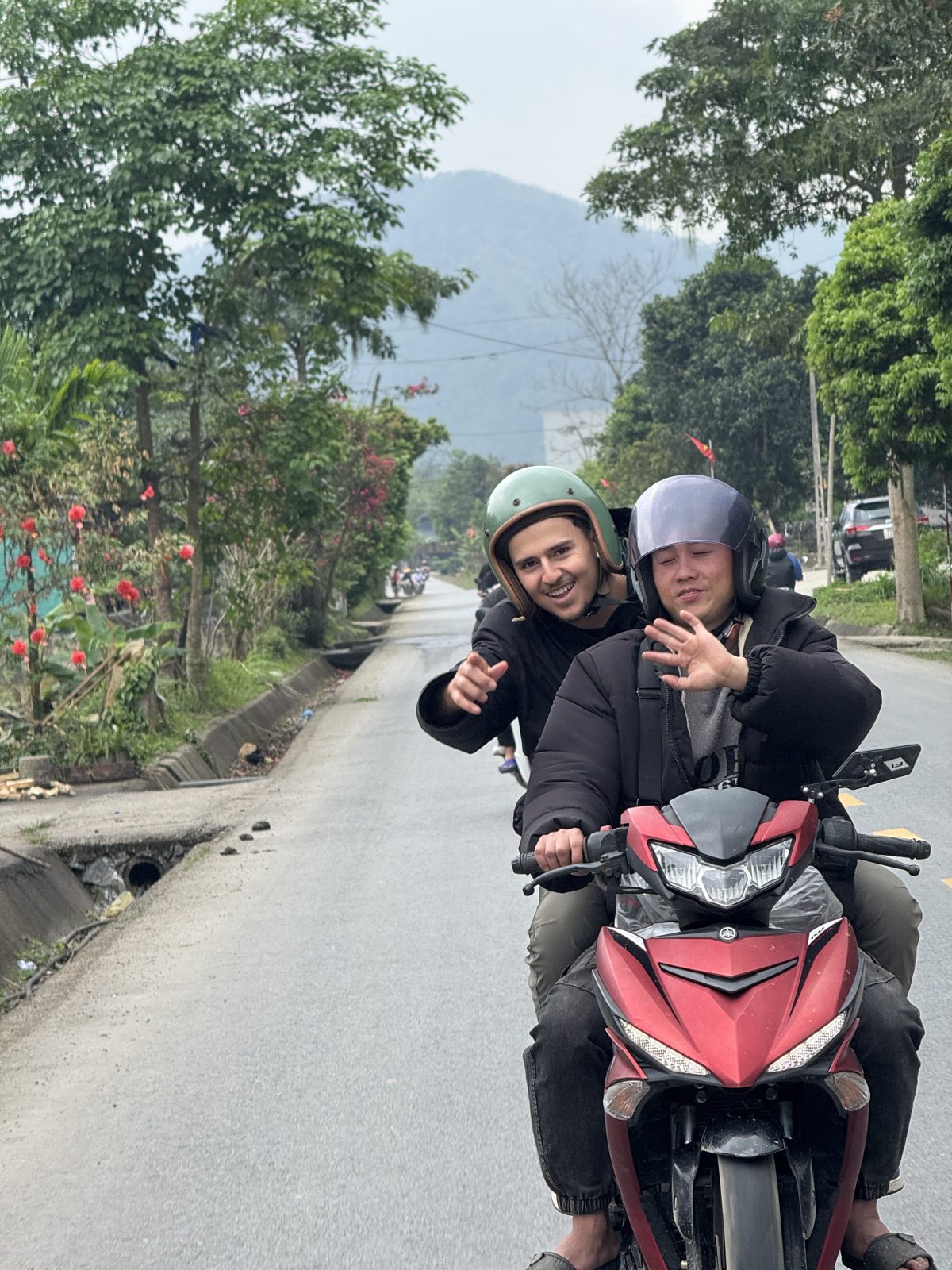Two riders on a motorbike on a Ha Giang road