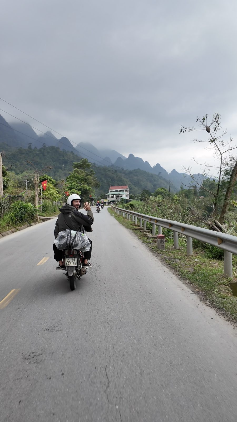 Solo rider on the road with karst mountains behind